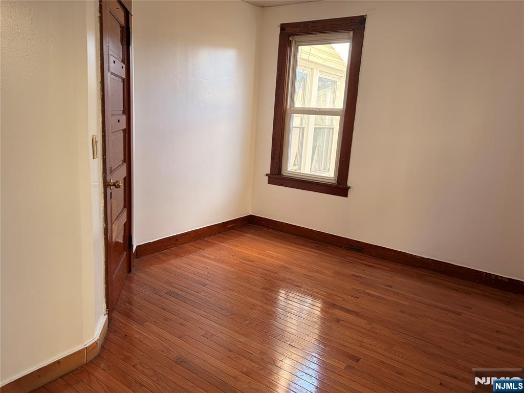 35 Marsellus Place, Unit 1 Garfield, NJ 07026 - Photo 28 of 37 an empty room with wooden floor and windows
