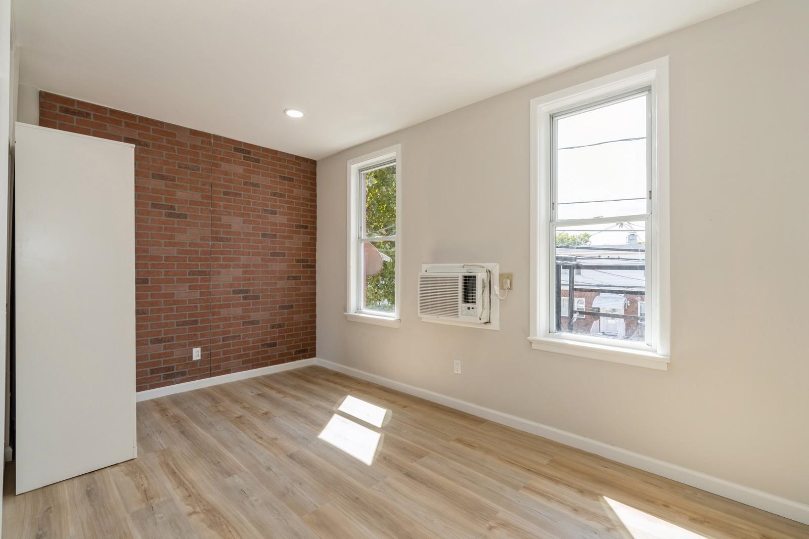 40 Beacon Avenue, Unit 5 Jersey City, NJ 07306 - Photo 11 of 20 a view of an empty room with wooden floor and a window