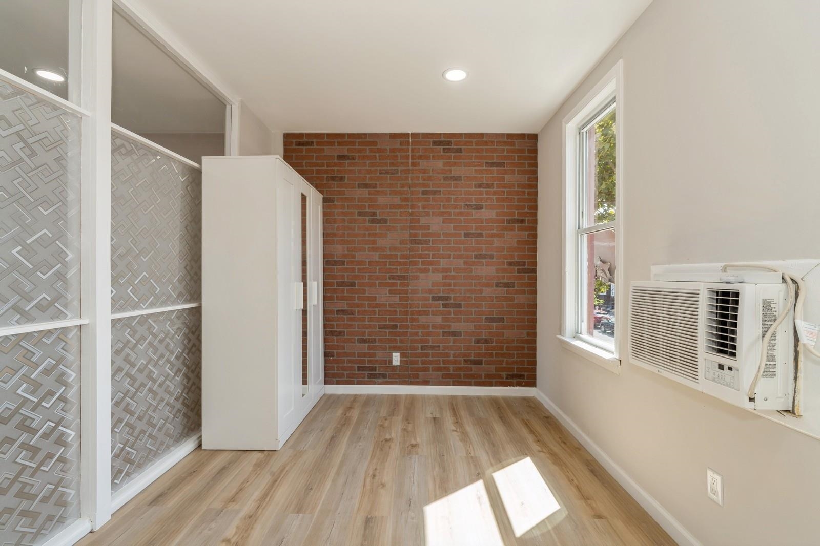 40 Beacon Avenue, Unit 5 Jersey City, NJ 07306 - Photo 12 of 20 wooden floor in an empty room with a window