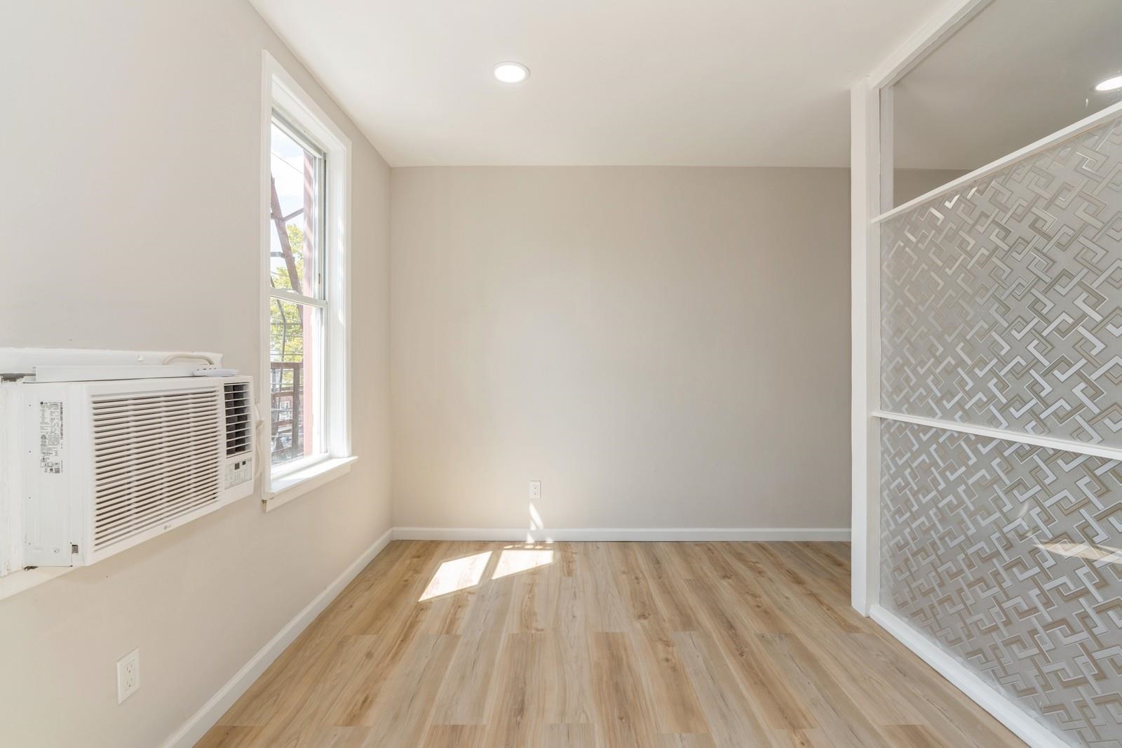 40 Beacon Avenue, Unit 5 Jersey City, NJ 07306 - Photo 14 of 20 an empty room with wooden floor and windows