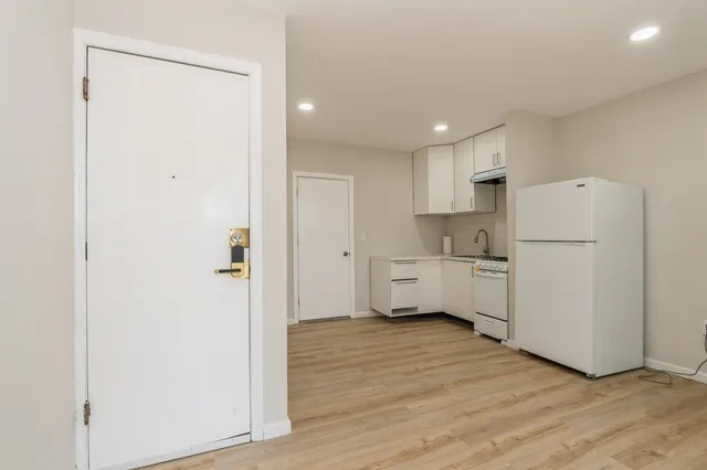 a kitchen with white cabinets and white appliances