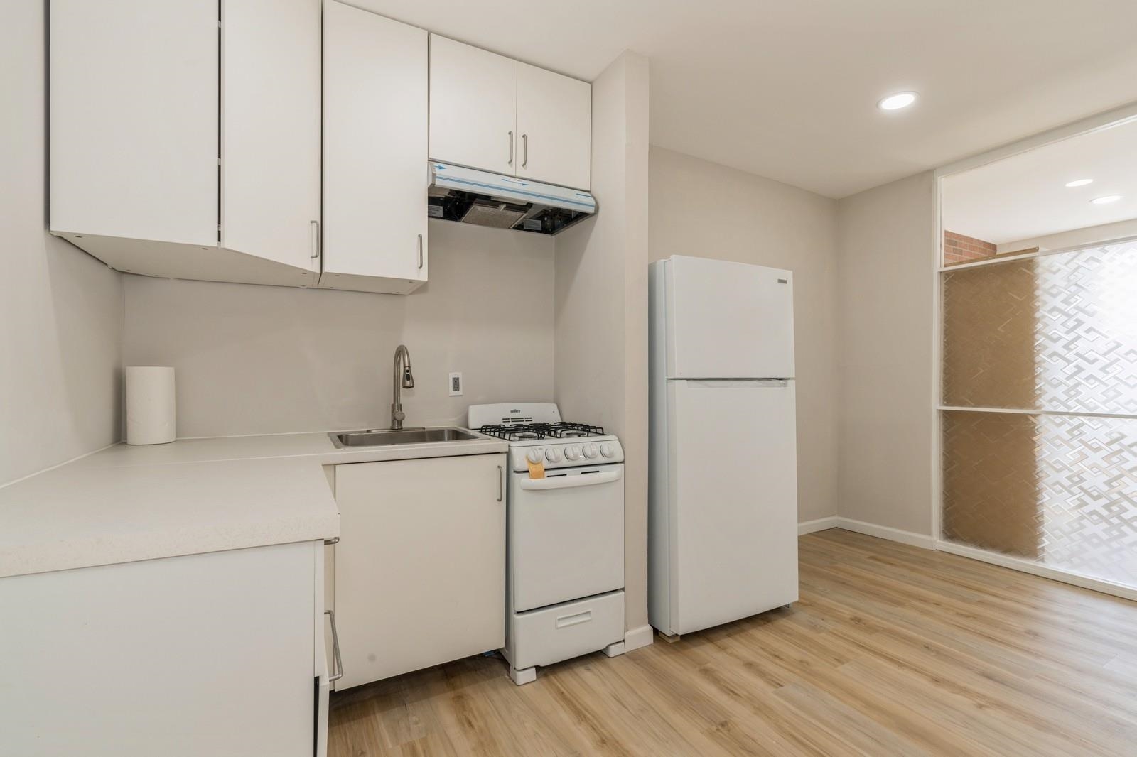 40 Beacon Avenue, Unit 5 Jersey City, NJ 07306 - Photo 19 of 20 a kitchen with stainless steel appliances granite countertop a refrigerator sink and white cabinets
