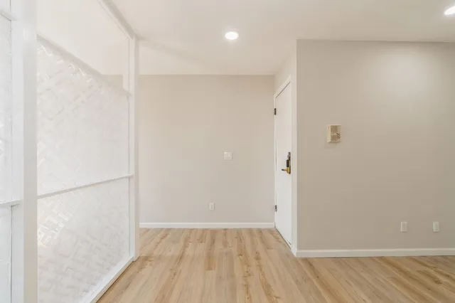 a view of an empty room with wooden floor