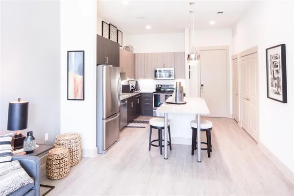 a kitchen with stainless steel appliances kitchen island granite countertop a refrigerator and a stove top oven