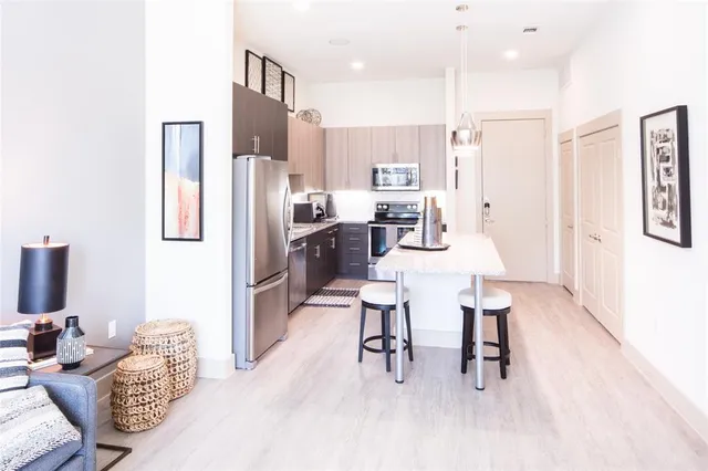 a kitchen with stainless steel appliances kitchen island granite countertop a refrigerator and a stove top oven