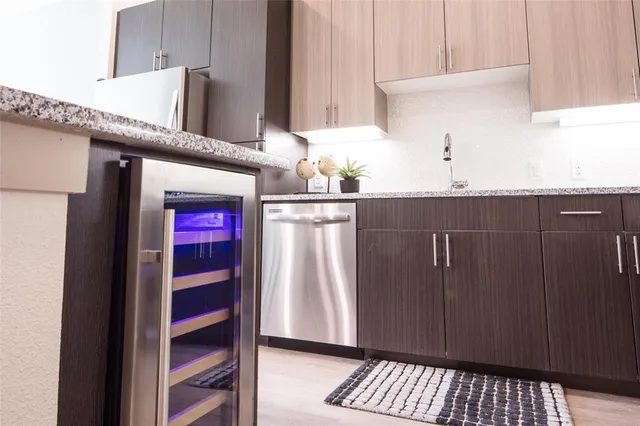 a kitchen with granite countertop a refrigerator and cabinets
