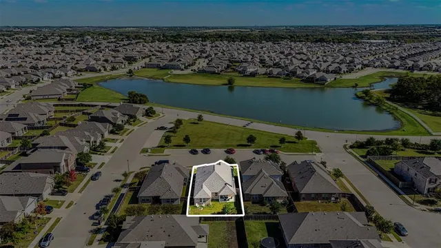 an aerial view of a house with a lake