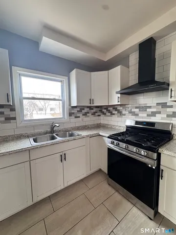 a kitchen with stainless steel appliances granite countertop a stove sink and cabinets
