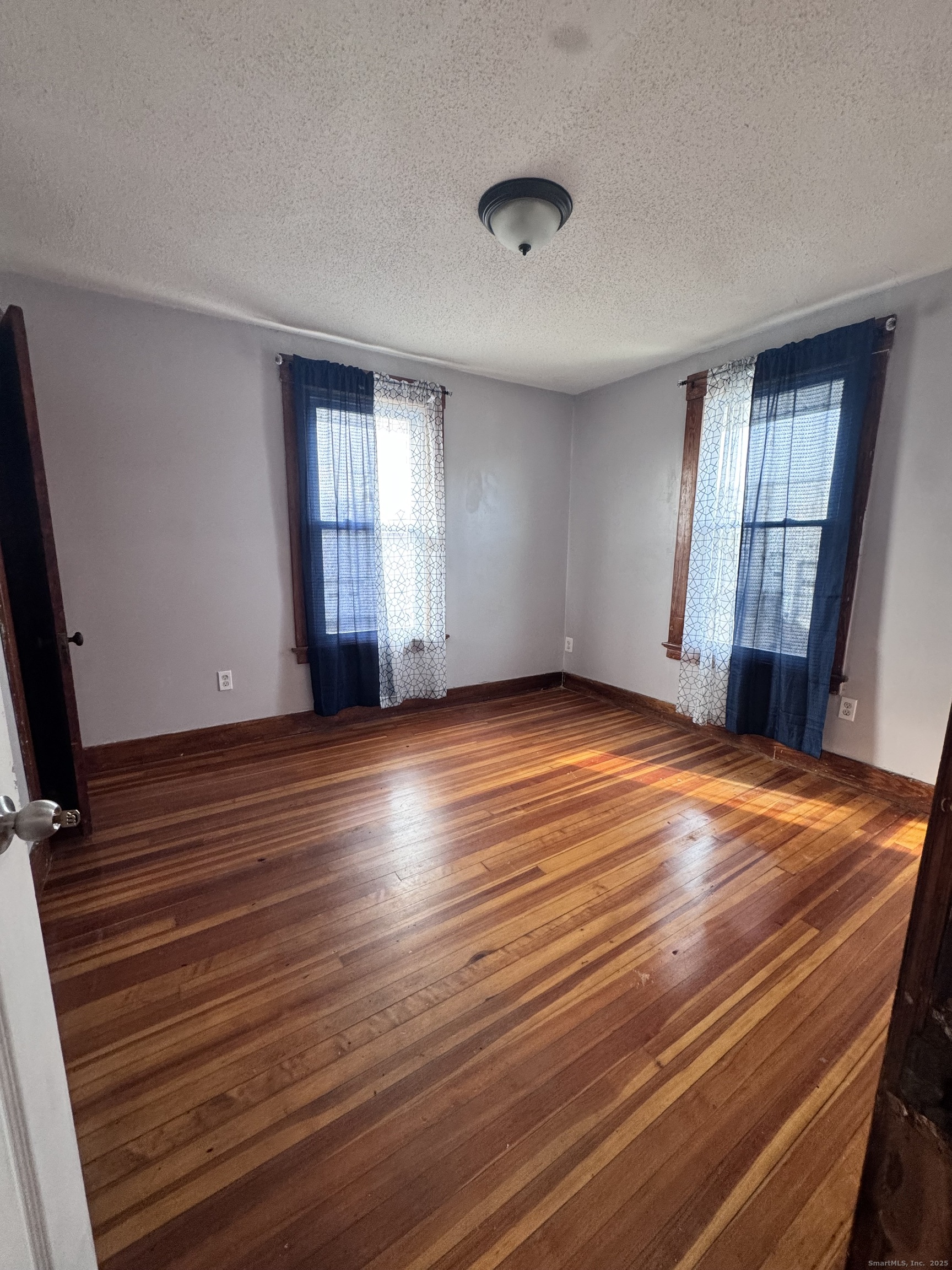62 Marne Street Hamden, CT 06514 - Photo 15 of 26 an empty room with wooden floor and windows