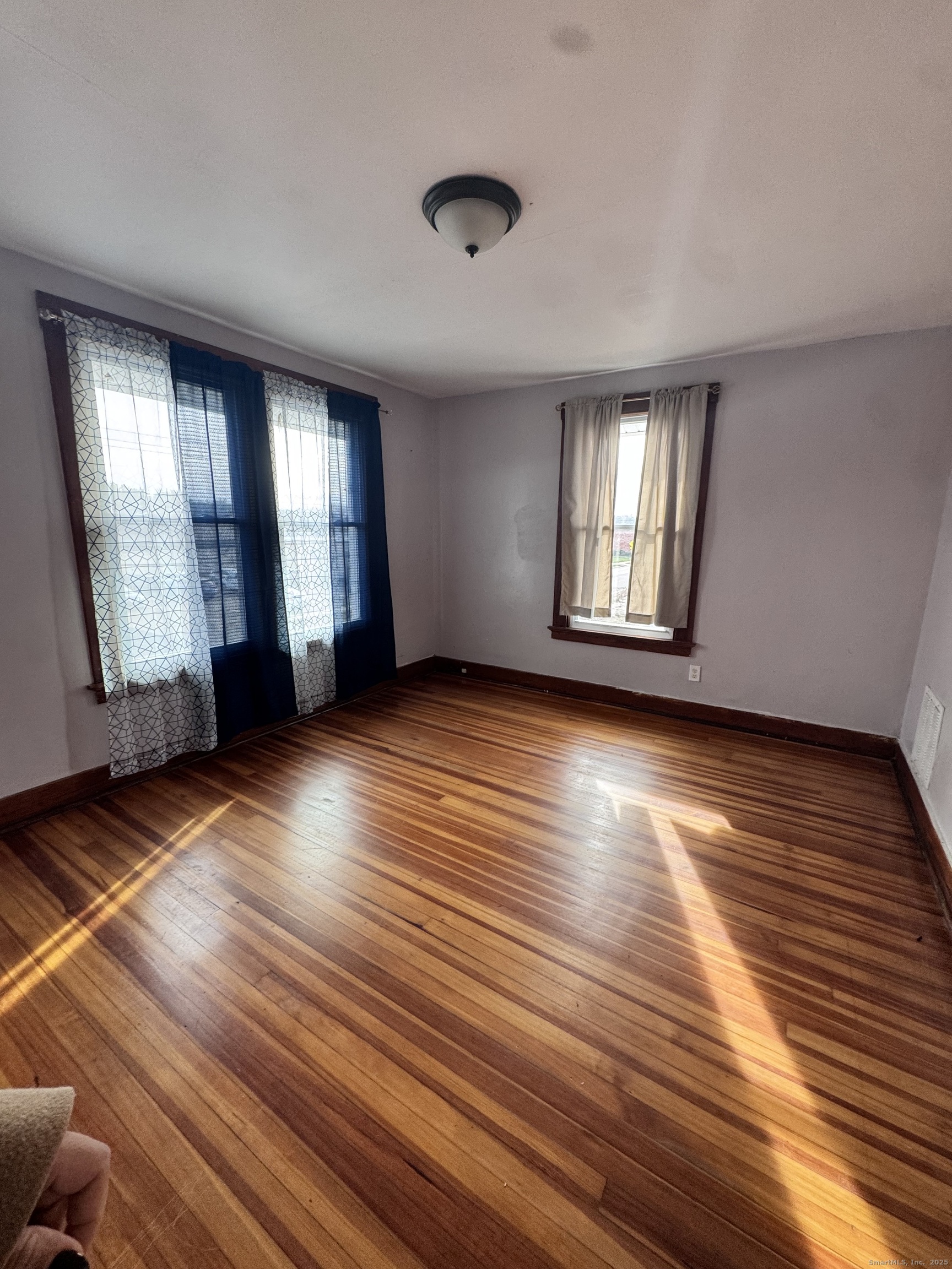 62 Marne Street Hamden, CT 06514 - Photo 3 of 26 an empty room with wooden floor and windows
