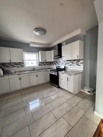 a kitchen with stainless steel appliances granite countertop a stove sink and cabinets