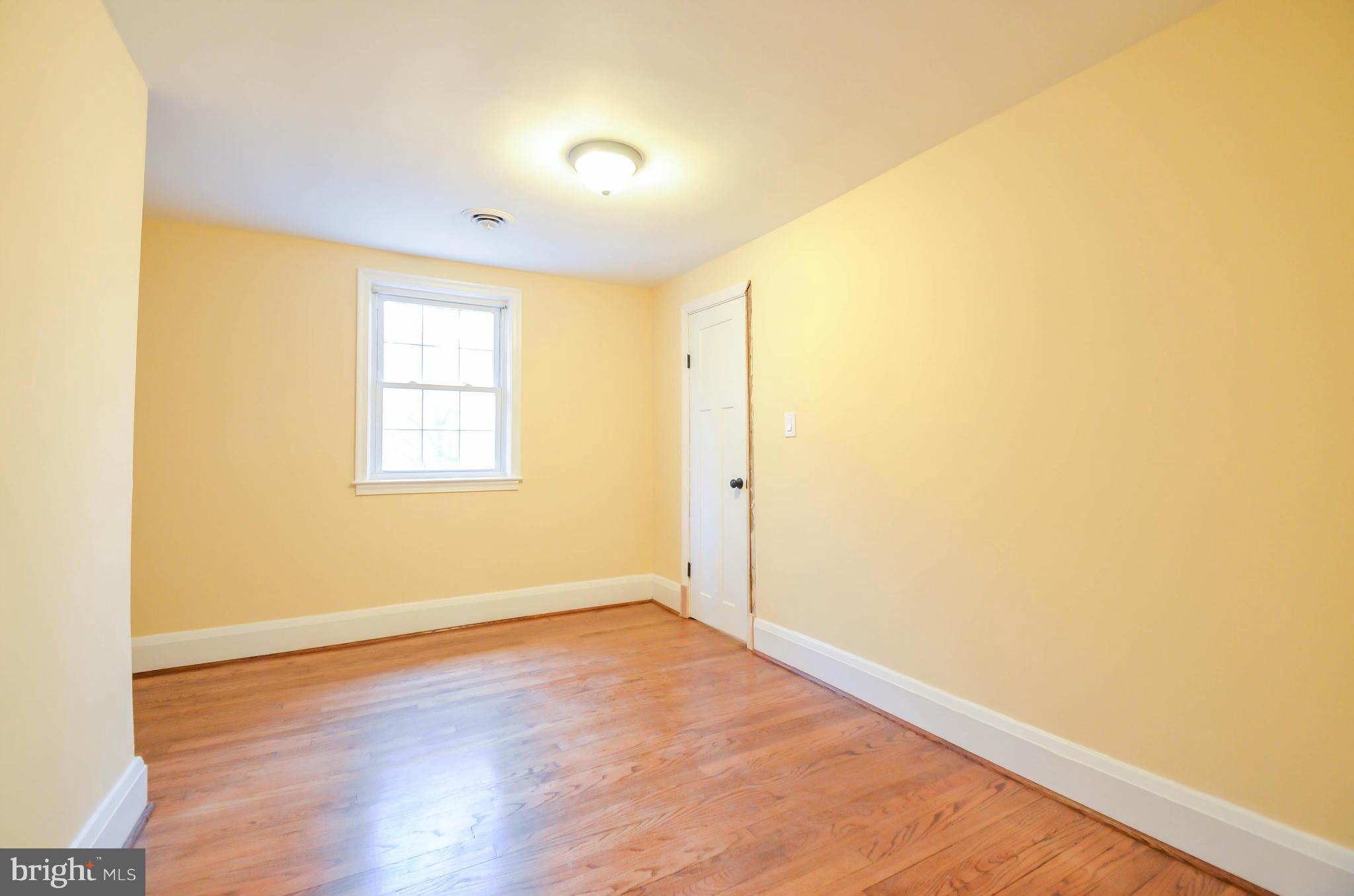 720 Overbrook Road Baltimore, MD 21212 - Photo 13 of 26 an empty room with wooden floor and windows
