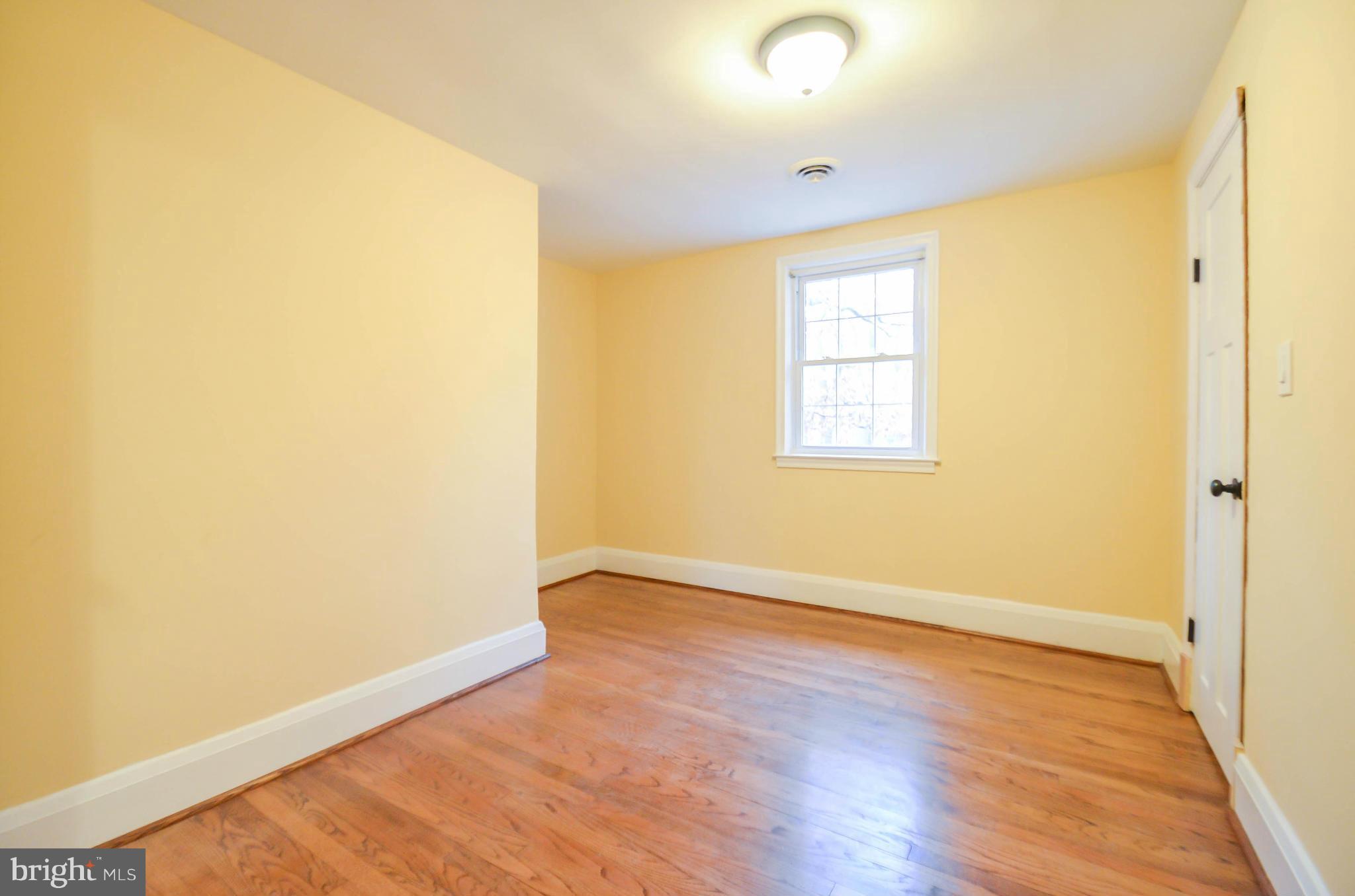 720 Overbrook Road Baltimore, MD 21212 - Photo 14 of 26 an empty room with wooden floor and windows