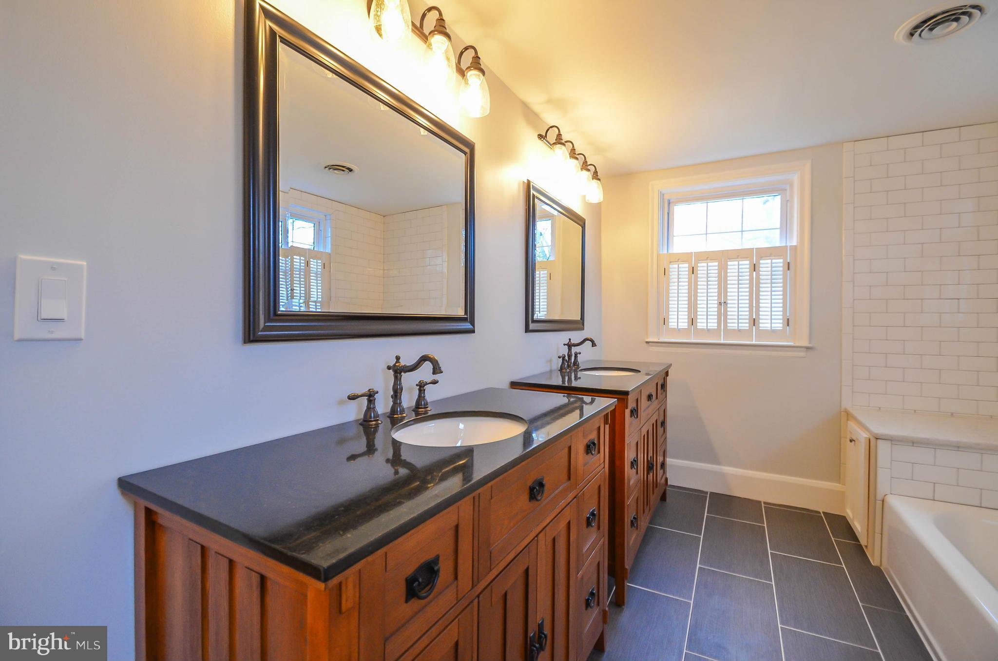 720 Overbrook Road Baltimore, MD 21212 - Photo 17 of 26 a bathroom with a granite countertop sink a mirror and a bathtub
