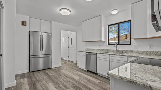 a kitchen with stainless steel appliances granite countertop a refrigerator sink and stove