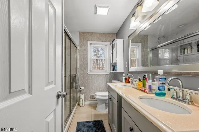a bathroom with a sink double vanity and a toilet