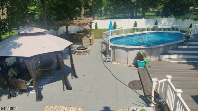 a view of a patio with table and chairs potted plants with wooden floor and fence