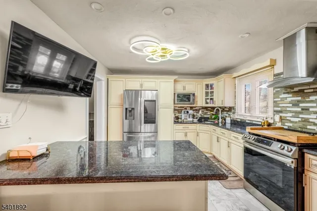 a kitchen with stainless steel appliances granite countertop a sink dishwasher stove and oven with wooden floor
