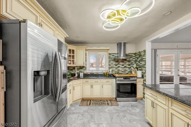 a kitchen with stainless steel appliances granite countertop a refrigerator and a stove top oven