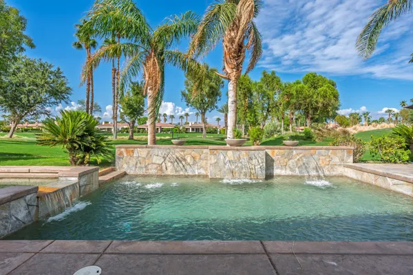 a living room with furniture a fireplace and a large window