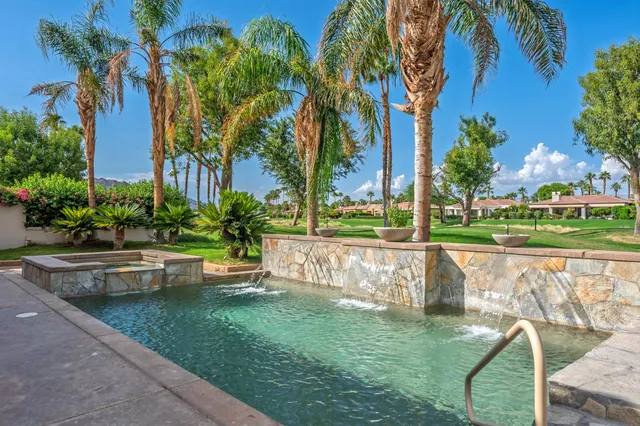 a spacious bedroom with a bed a chandelier and a large window
