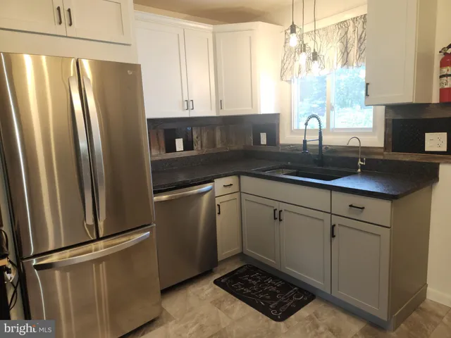 a kitchen with stainless steel appliances granite countertop a refrigerator sink and cabinets