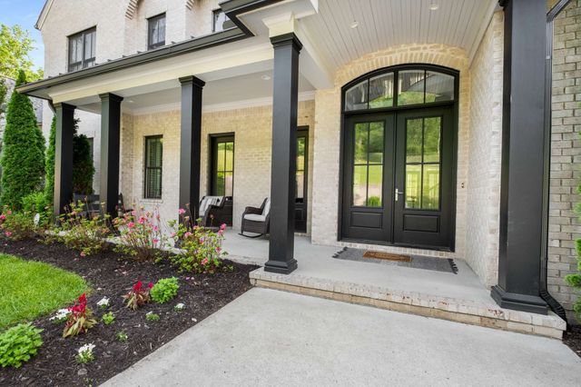 a view of a dining room and livingroom with furniture wooden floor a chandelier