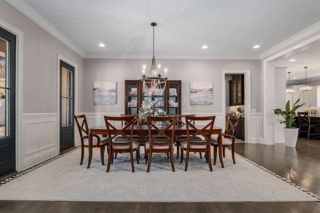 a living room with furniture kitchen view and a chandelier