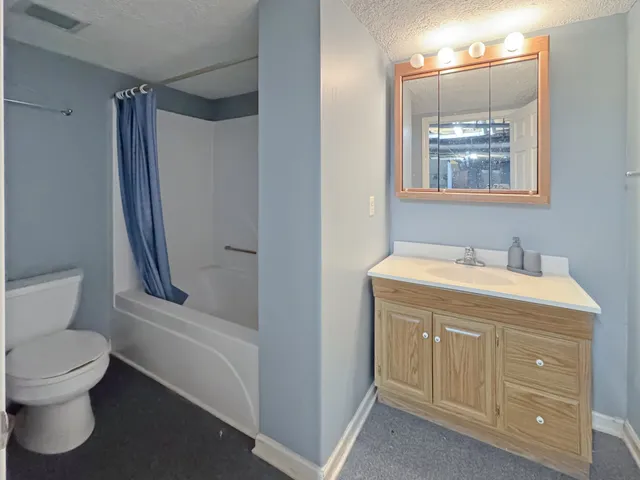 a bathroom with a granite countertop sink toilet and shower