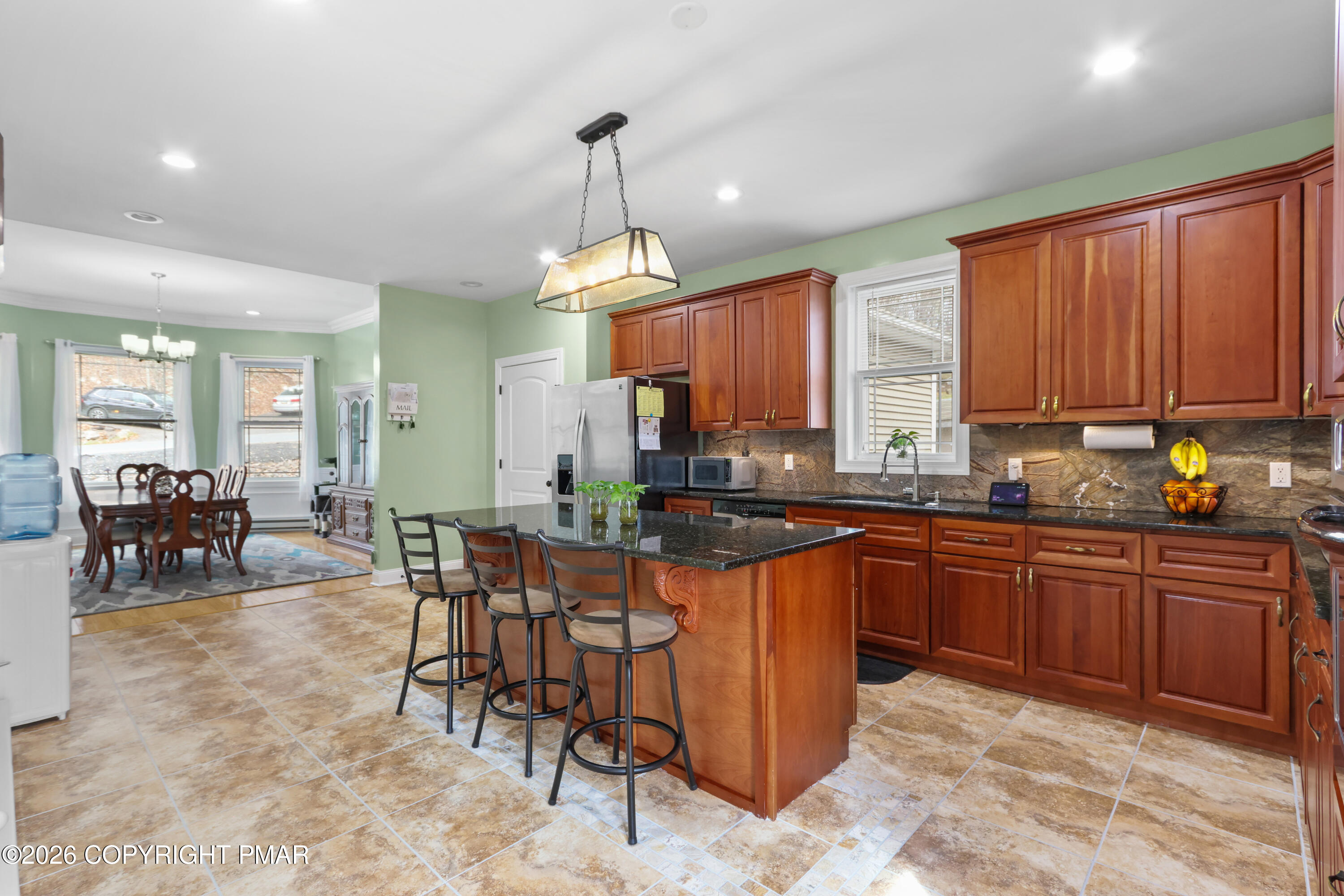1007 Hampstead Road Bushkill, PA 18324 - Photo 12 of 68 a kitchen with stainless steel appliances granite countertop wooden cabinets a dining table and chairs