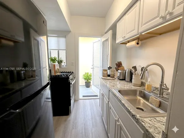 a kitchen with a sink a counter top space a stove and cabinets