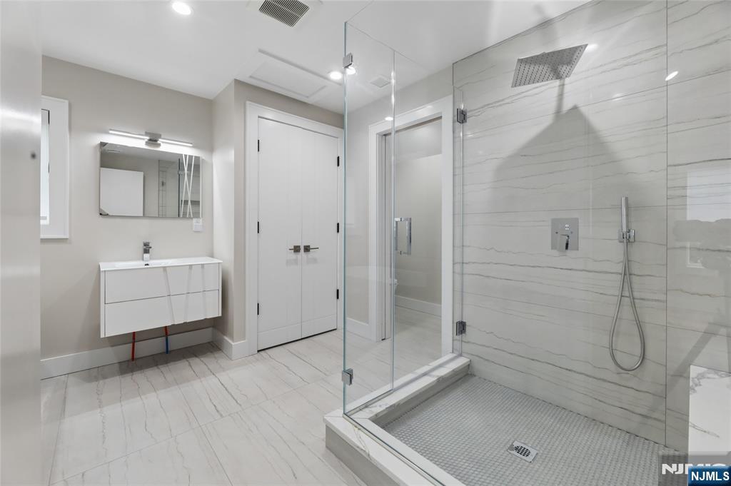 31 Engleside Street Cresskill, NJ 07626 - Photo 32 of 49 a bathroom with a shower sink and mirror