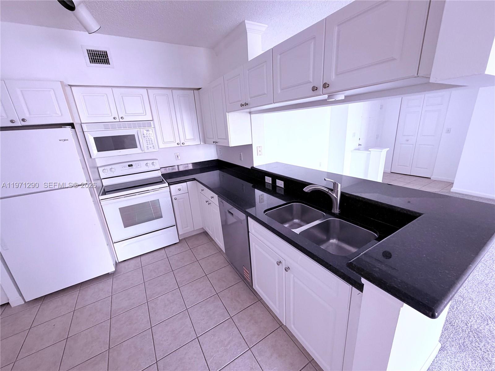 17150 North Bay Road, Unit 2911 Sunny Isles Beach, FL 33160 - Photo 4 of 43 a kitchen with granite countertop a sink stainless steel appliances and cabinets