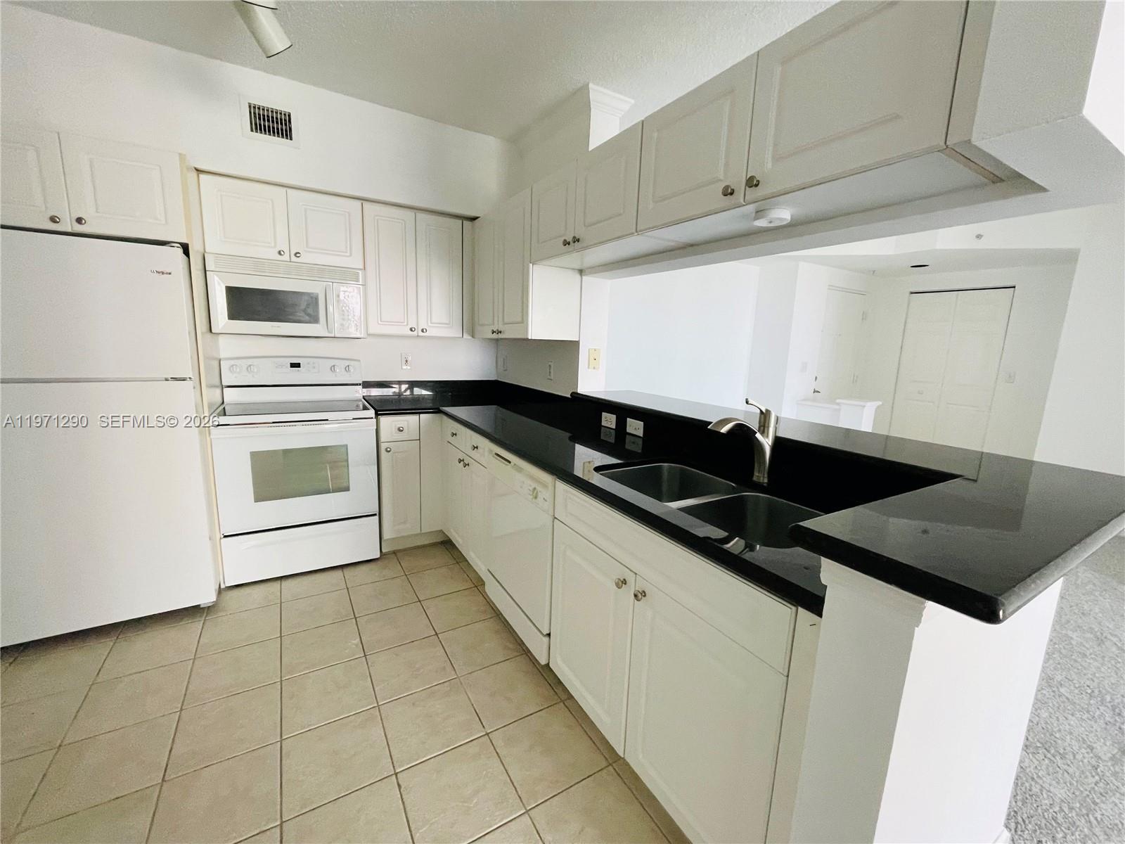 17150 North Bay Road, Unit 2911 Sunny Isles Beach, FL 33160 - Photo 6 of 43 a kitchen with stainless steel appliances granite countertop a sink stove and cabinets