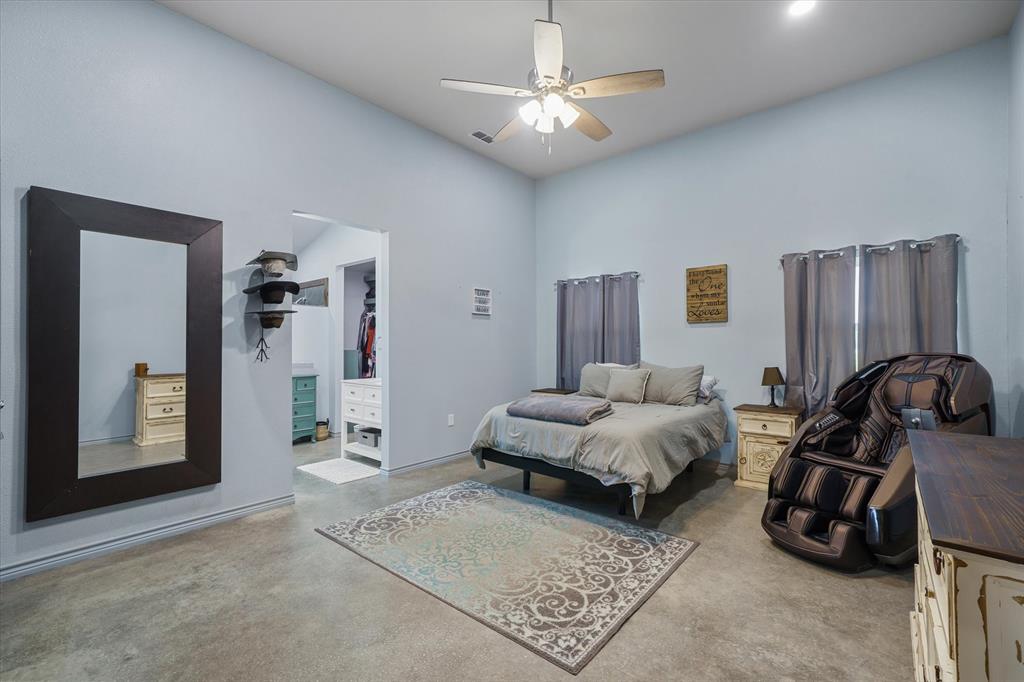 1026 VZ County Road Canton, TX 75103 - Photo 9 of 40 a spacious bedroom with a bed and a chandelier