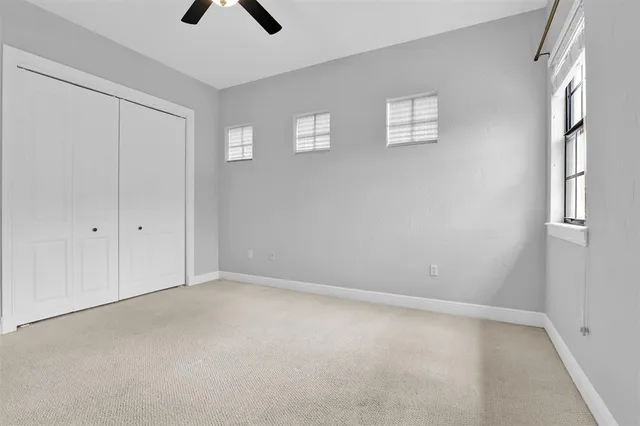 an empty room with windows and closet