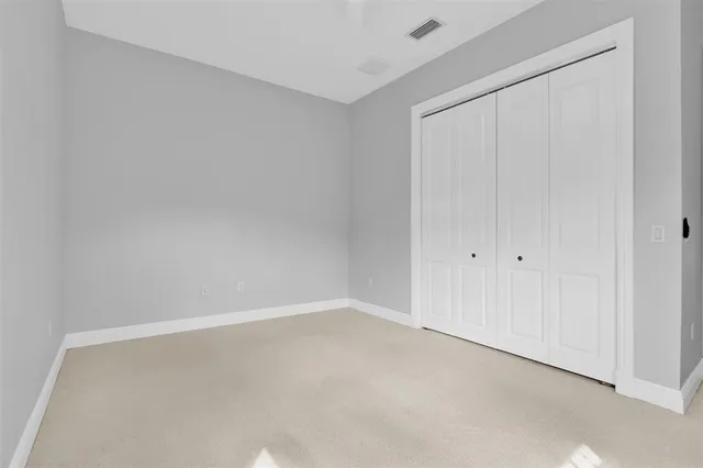 a kitchen with stainless steel appliances granite countertop a refrigerator a sink dishwasher a oven and white cabinets with wooden floor