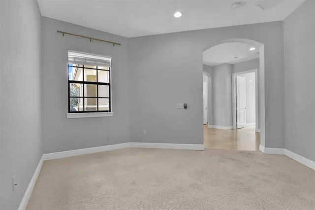 a view of an empty room with a kitchen and a window