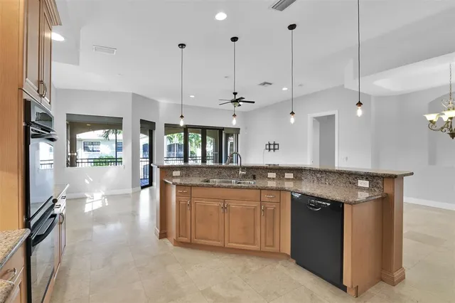 a large white kitchen with granite countertop a sink