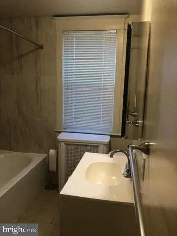 a bathroom with a sink a mirror and a bathtub