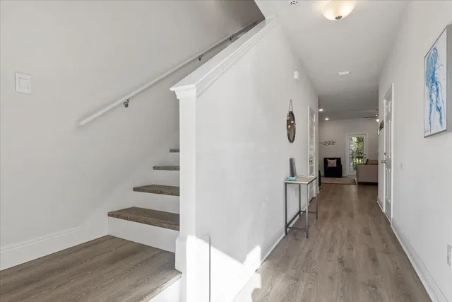 a view of a hallway with wooden floor and staircase