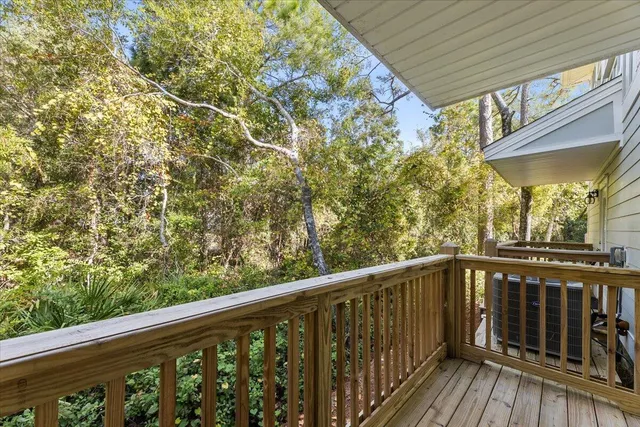 a view of a balcony with wooden floor and fence