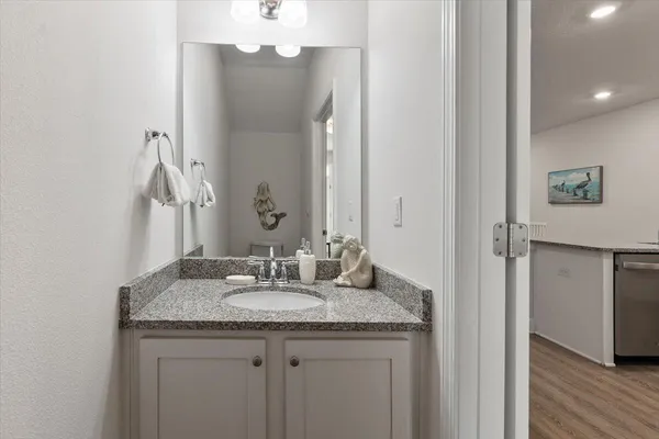 a bathroom with a granite countertop sink and a mirror