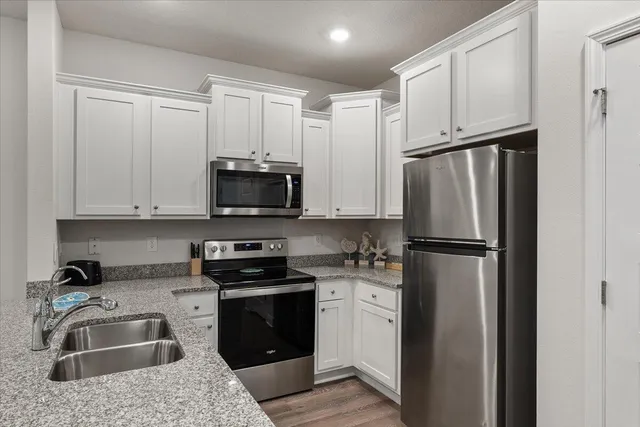 a kitchen with refrigerator a microwave and sink