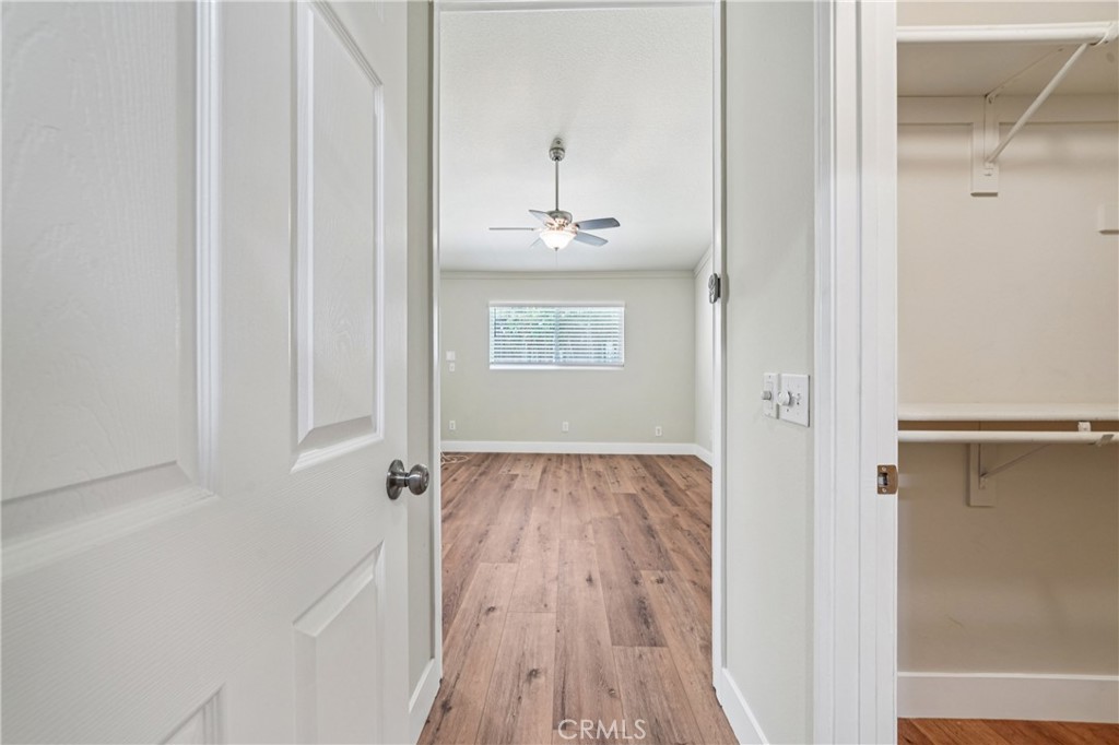 7271 Venosa Place Rancho Cucamonga, CA 91701 - Photo 13 of 32 a view of a hallway with wooden floor and a bathroom