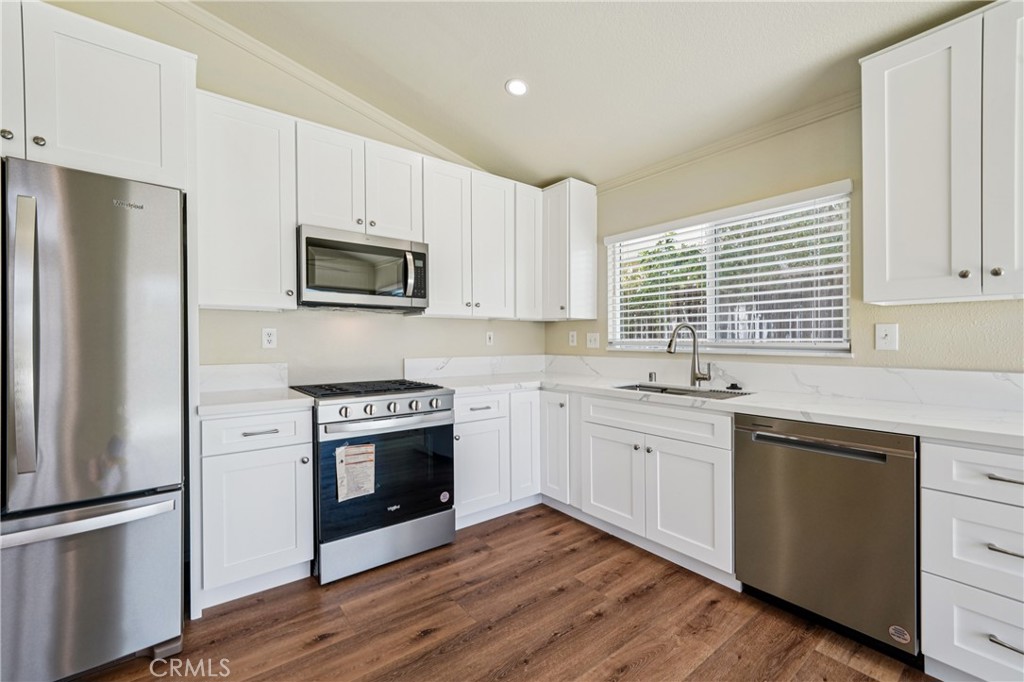 7271 Venosa Place Rancho Cucamonga, CA 91701 - Photo 7 of 32 a kitchen with white cabinets and stainless steel appliances
