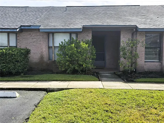 a view of a house with a yard and large tree
