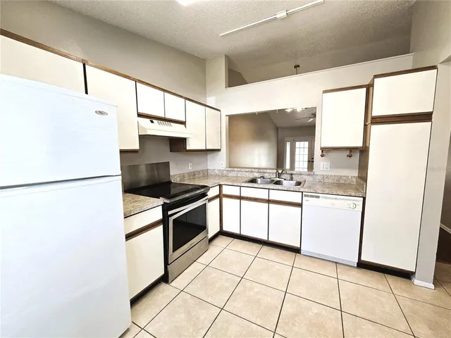 a kitchen with stainless steel appliances granite countertop a refrigerator sink and cabinets