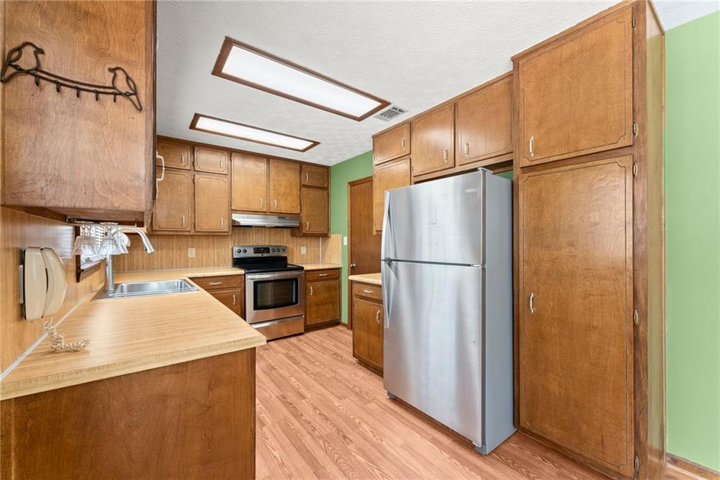 4691 Lucerne Valley Road Southwest Lilburn, GA 30047 - Photo 12 of 55 a kitchen with stainless steel appliances a refrigerator and a stove top oven