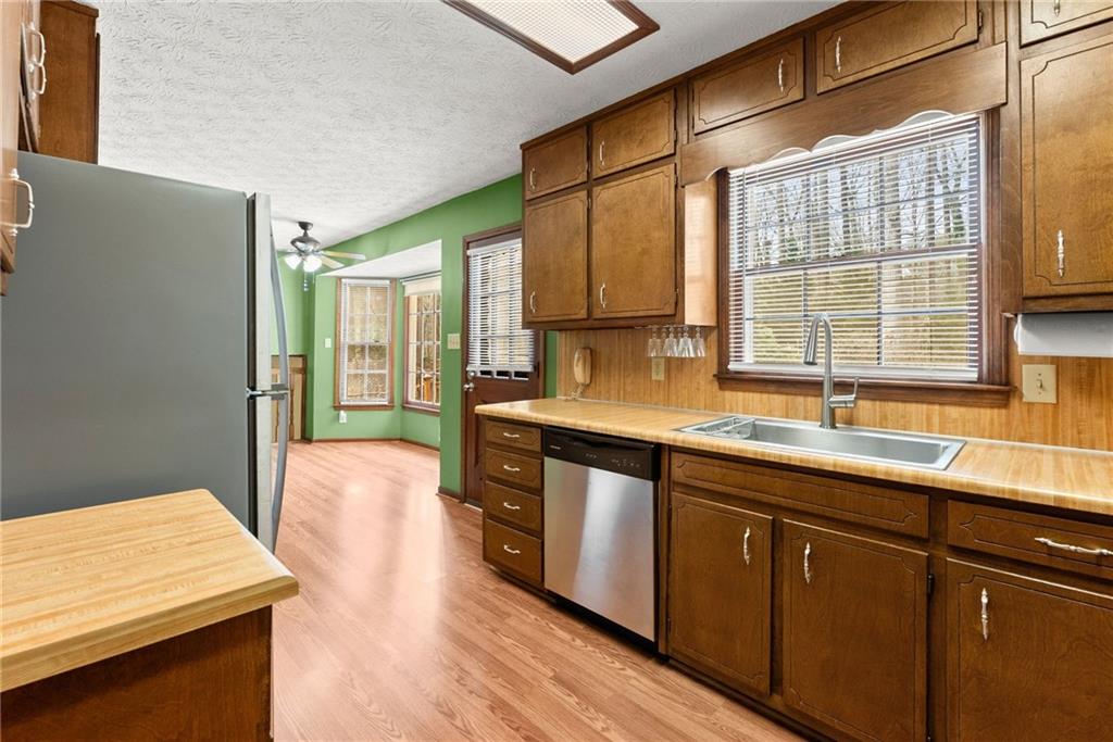 4691 Lucerne Valley Road Southwest Lilburn, GA 30047 - Photo 14 of 55 a kitchen with stainless steel appliances granite countertop wooden cabinets a sink and a window